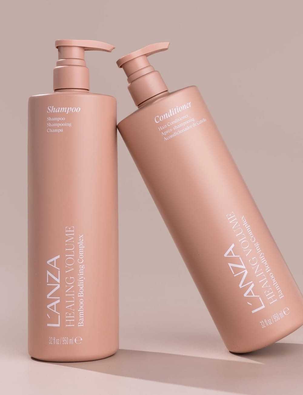 L'ANZA Healing Volume shampoo and conditioner bottles on a neutral background.