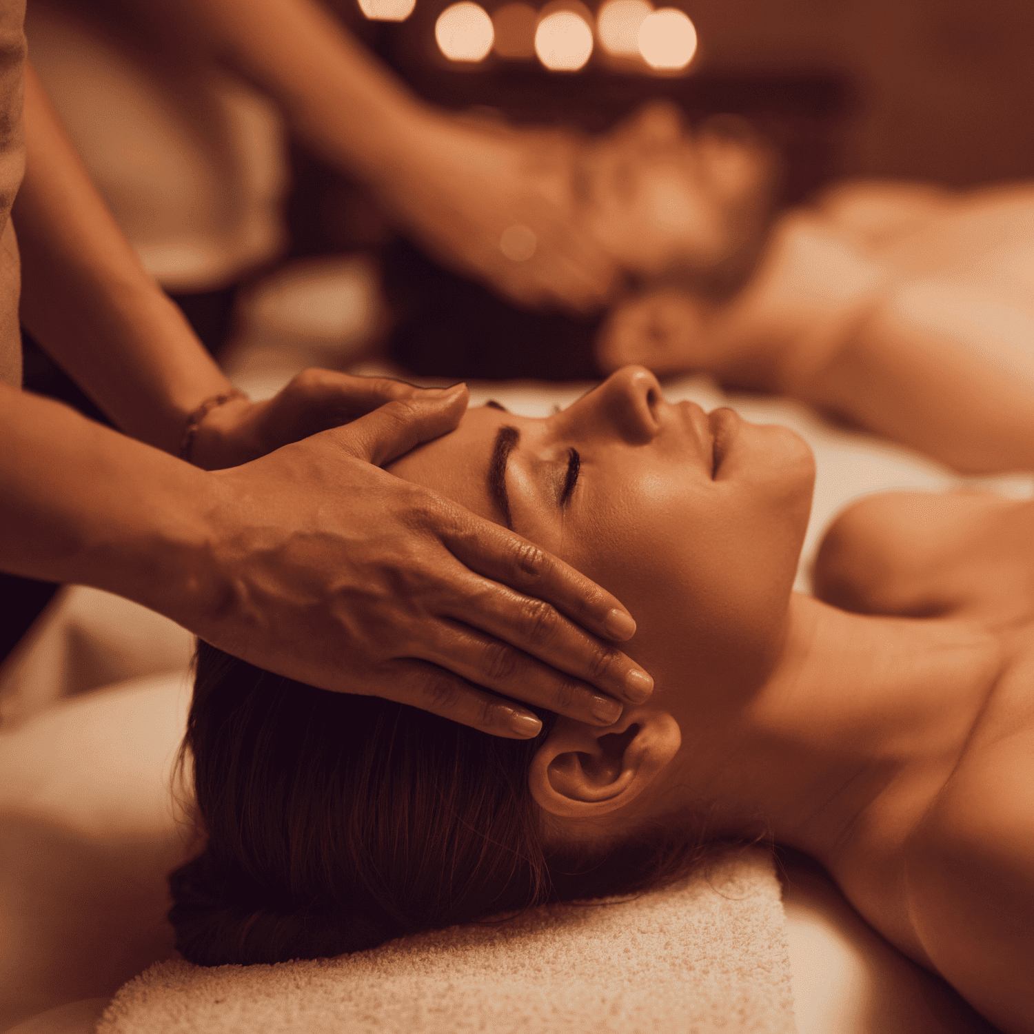 Two people enjoying a relaxing head massage in a spa setting.
