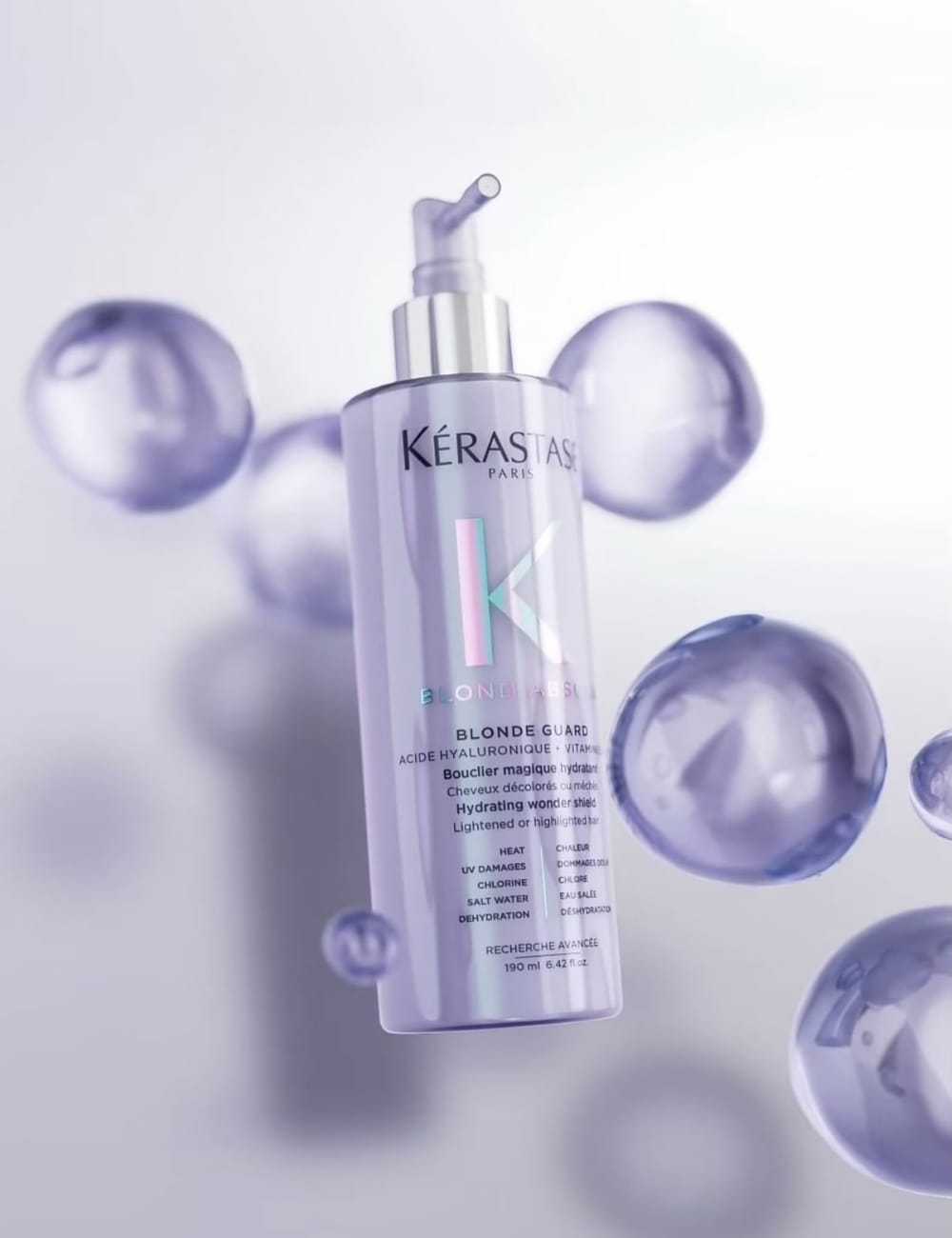 Kérastase Blond Absolu hair product bottle surrounded by floating purple bubbles.